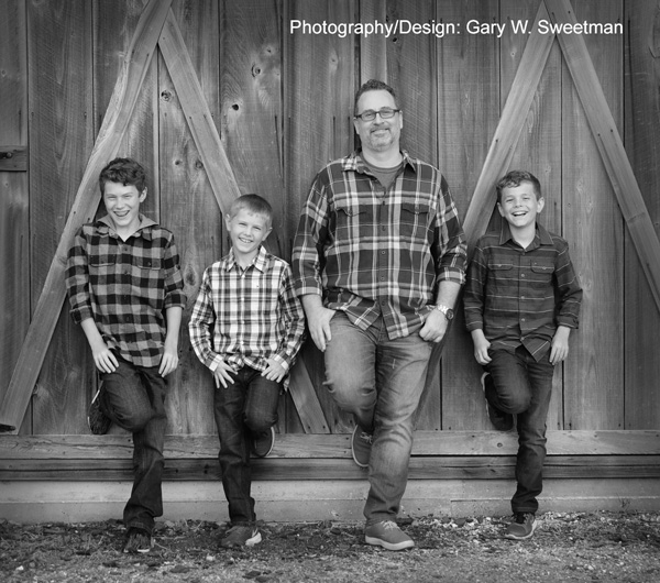 location photo with kids and barn in black and white